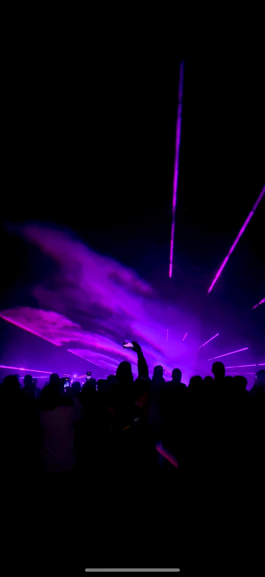 Professionelle Lasershow mit cyan- und magenta-farbenen Strahlen